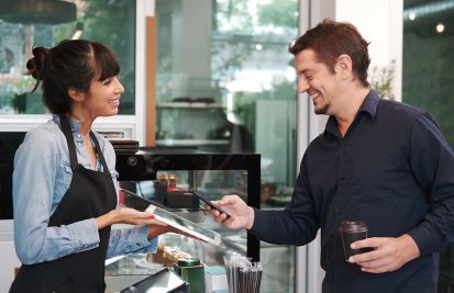 man using mobile payment in coffee shop