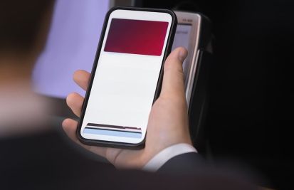 man holding mobile device against a card reader