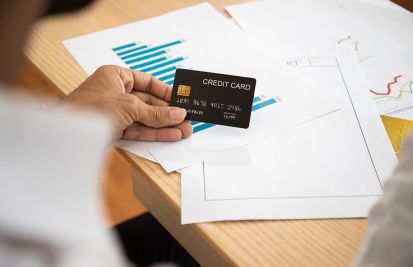 woman holding credit card on desk