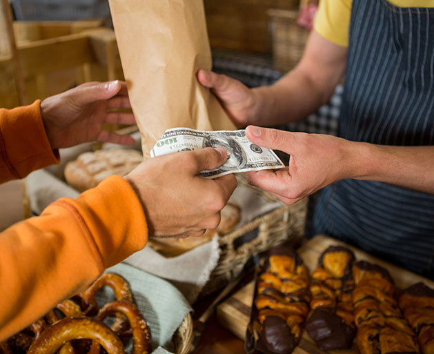 Someone paying cash for an item in a paper bag